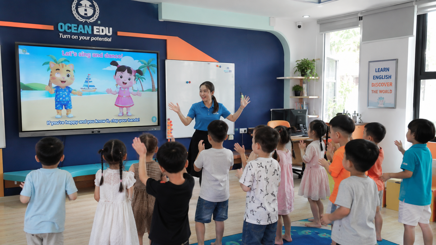 Phòng học ngoại ngữ thông minh mầm non với màn hình tương tác và trẻ học tiếng Anh qua bài hát trò chơi